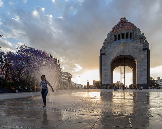 Girl running through fountain Monumento a la Revolución Mexico City